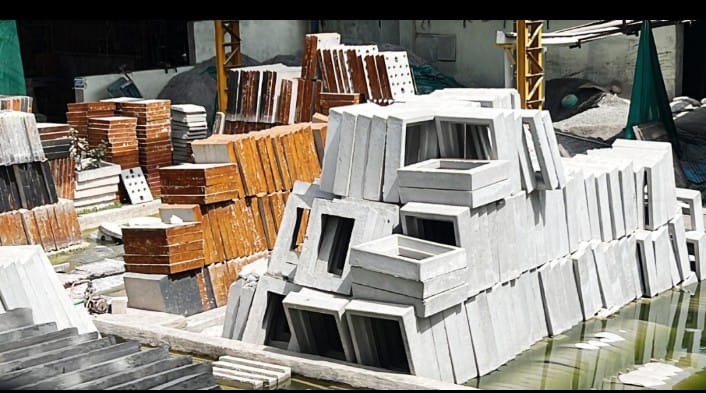 RCC Concrete Covers in Bulk, Stack of RCC concrete cover slabs stored in bulk for drainage use, Bulk quantity of reinforced concrete covers with ventilation slots, Multiple RCC concrete drain covers arranged for bulk supply, Precast RCC covers stored in large quantities at construction site